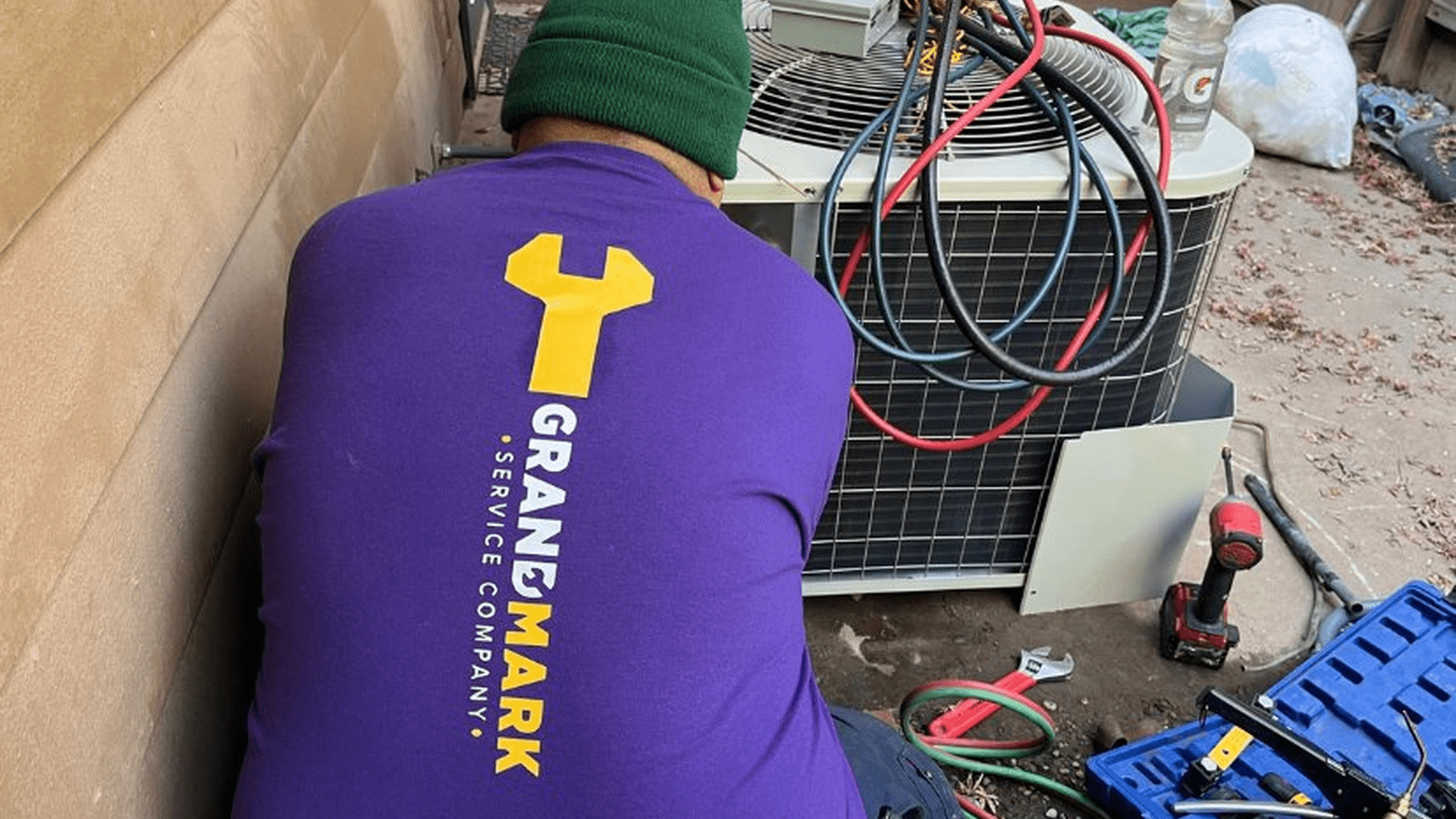 Grandmark HVAC technician servicing a rooftop air conditioning unit in California